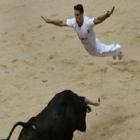 Foliões desafiam o perigo saltando sobre touros na Espanha