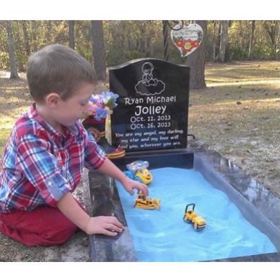 Mulher adapta túmulo para filho poder 'brincar' com o irmão morto