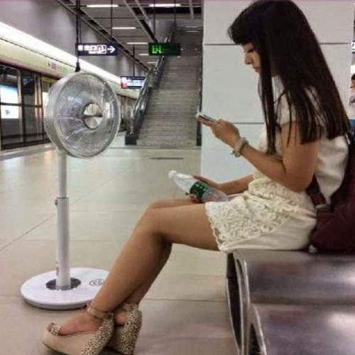  Menina chinesa leva ventilador para o mêtro por causa do calor.