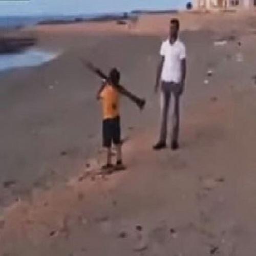 Criança atira míssil com RPG na beira da praia.