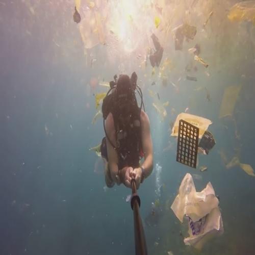 Oceano de plástico,homem nada no mar da Indonésia cercado de lixo