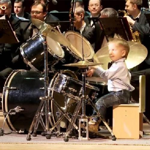 Garotinho bastante talentoso toca bateria com Orquestra Filarmônica