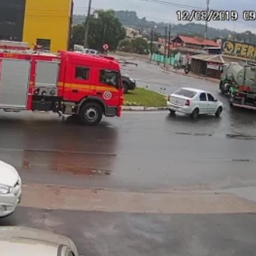 Carro pega fogo do lado do caminhão de bombeiros