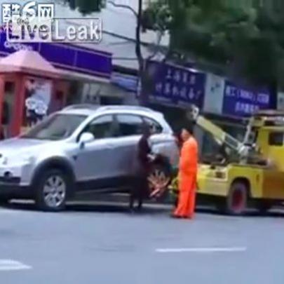 Chinesa arrasta guincho que ia levar seu carro